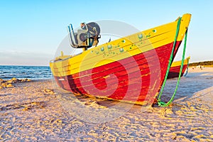 Fishing boats on the sandy beach during sunset