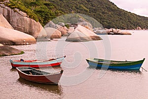 fishing boats at sea with rocks beside photo