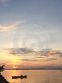 fishing boats on the seashore as the sun begins to set