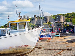 Fishing boats on the shore line conway castle behind