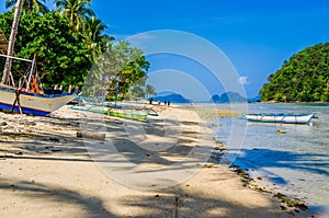 Fishing boats on shore under palms.Tropical island landscape. El- Nido, Palawan, Philippines