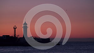 Fishing boats at sunrise swim near the lighthouse