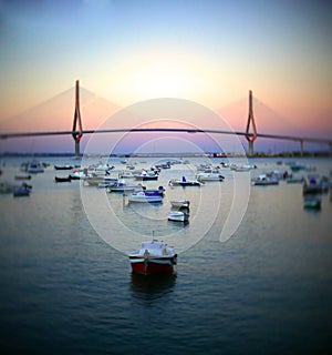 Fishing boats in sunset at the Puente de la Constitucion, called La Pepa, in the bay of Cadiz, Andalusia. Spain.