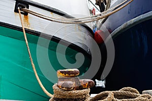 Fishing Boats Tied To Rusty Harbor Bollard