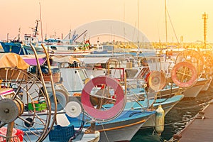 Fishing boats and yachts at sunset in Limassol old port, Cyprus. Mediterranean sea and Greek culture