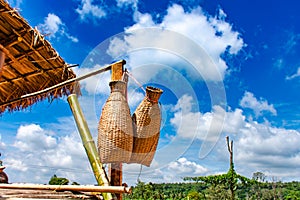 Fishing creel, Bamboo basket hang on the terrace of wood and bright blue sky.