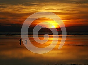 Fishing at dawn under an incredible orange sunrise, Bali.