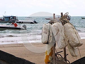 Fishing elements perched on the beach with the sea in the background.