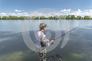 Fishing. Fisherman in action catch fish at lake pond