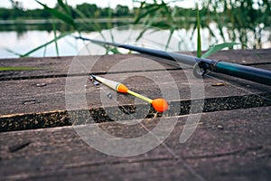 Fishing float, fishing bobber on the wooden pier. Fishing rod and fishing equipment on the jetty. Fishing concept.