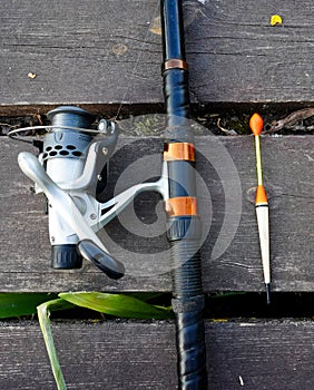 Fishing float, fishing bobber on the wooden pier. Fishing rod and fishing equipment on the jetty. Fishing concept.