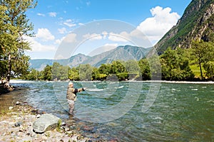 Fishing by flyfishing on the river. Russia Siberia. River Chelushman