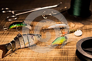 Fishing gear, artificial bait on a predator on a wooden background, top view wobblers and various bait cords and tongs