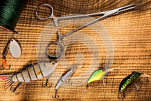 Fishing gear, artificial bait on a predator on a wooden background, top view wobblers and various bait cords and tongs