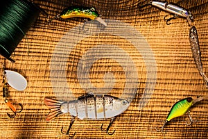 Fishing gear, artificial bait on a predator on a wooden background, top view wobblers and various bait cords and tongs