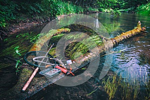 Fishing gear lying on the bank of a forest stream. Fly fishing and tenkara