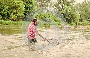 Fishing hobby. Bearded brutal fisher catching trout fish with net. If fish regularly you know how rewarding and soothing