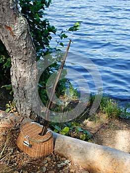 Fishing hole- Antique wooden fishing pole and small wicker basket for fishing lures