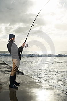 Fishing, holiday and travel with man at beach for adventure, relax and hobby break. Sunset, calm and patience with male