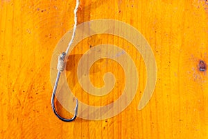Fishing hook on a wooden background. Free place.