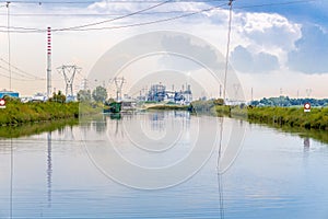 Fishing huts in brackish lagoon with industries