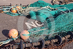 Fishing industry - fish nets placed against word NO, on quayside, Bideford, UK. Maybe message.