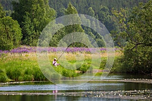 Fishing on the lake with lilies in rural location