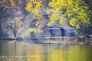 Fishing lake with piers and huts on a sunny autumn day