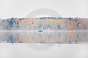 Fishing on the lake Senezh in Solnechnogorsk in the fall. The fog, the wind, the silhouette of a fisherman in a boat