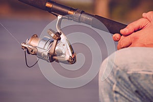 Fishing on the lake. Spinning reel Fisherman holding fishing rod