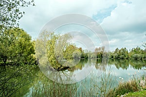 Fishing Lake Surrounded By Trees Reflected In The Calm Water