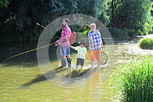 Fishing. Little boy fly fishing on a lake with his father and grandfather. Fishing in river. Young - adult concept.