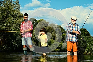 Fishing. Little boy fly fishing on a lake with his father and grandfather. Grandfather and father with cute child boy