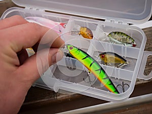 Fishing lures and accessories in the box background. Focus in the center of the bait