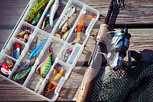 Fishing Lures in tackle boxes with spinning rod and net