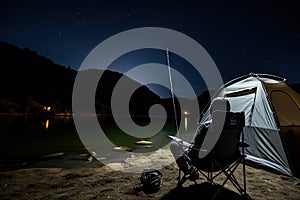 Fishing Man is Sitting at Night by Lake, Fishing Chair, Outdoor Tent, Fisherman Holds a Fishing Rod