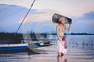 Fishing man use bamboo fish trap to catch fish in lake