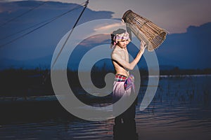 Fishing man use bamboo fish trap to catch fish in lake