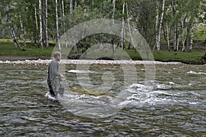 Fishing on the mountain river fishing rod. Fisherman fishing in the mountains. Trout fishing.