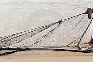 Fishing net being stretched by fishermen after working at sea