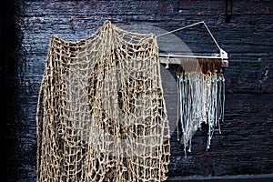 Fishing Net And Fish Hooks Hang On Dark Shiplap