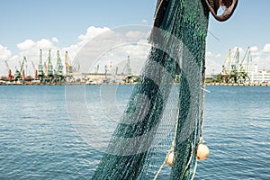 Fishing net hanging on board on fishing boat docked in the harbor