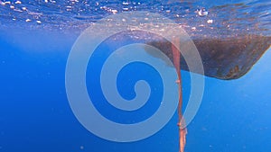 Fishing Net Hanging From Boat Under Sea in Underwater