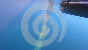 Fishing Net Hanging From Boat Under Sea in Underwater