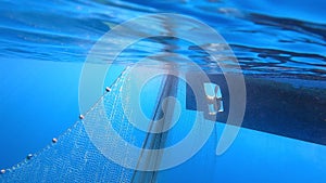 Fishing Net Hanging From Boat Under Sea in Underwater