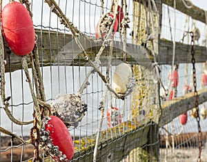 Fishing net with red floats hanging on a fence waiting for better weather