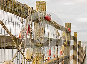 Fishing net with red floats hanging on a fence waiting for better weather