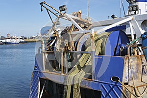 Fishing net on a winch aboard a blue fishing boat