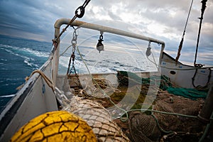 Fishing nets are on the deck of a small fishing ship