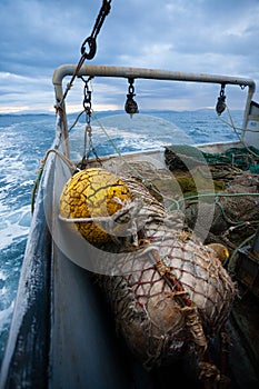 Fishing nets are on the deck of a small fishing ship